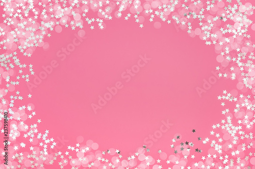 Pink holiday background with star glitter and bokeh. Top view, copy space. Flat lay