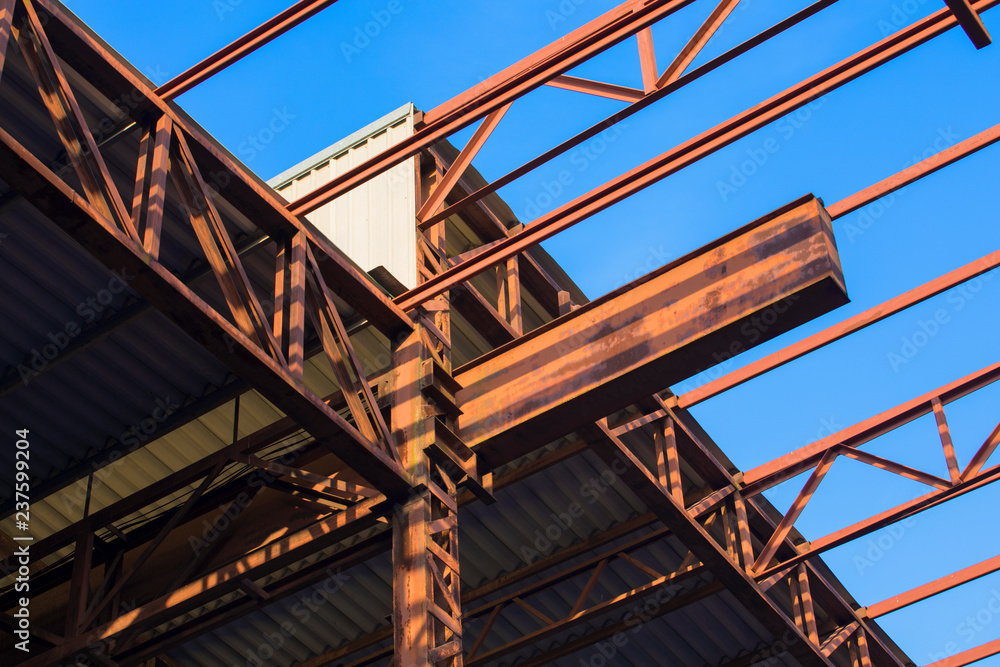 View of the steel frame and clear blue sky. Roofs under construction View of the steel frame and clear blue sky. Roofs under construction