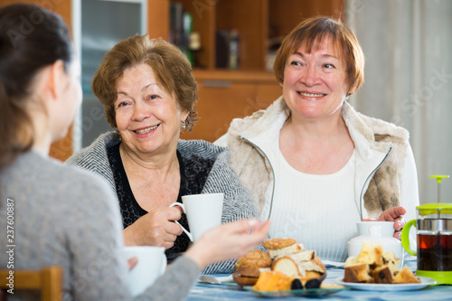 Young female and mature women drinking tea and talking