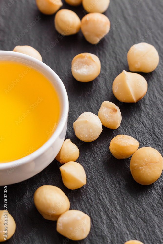 delicious macadamia nuts on a dark stone background delicious macadamia nuts on a dark stone background