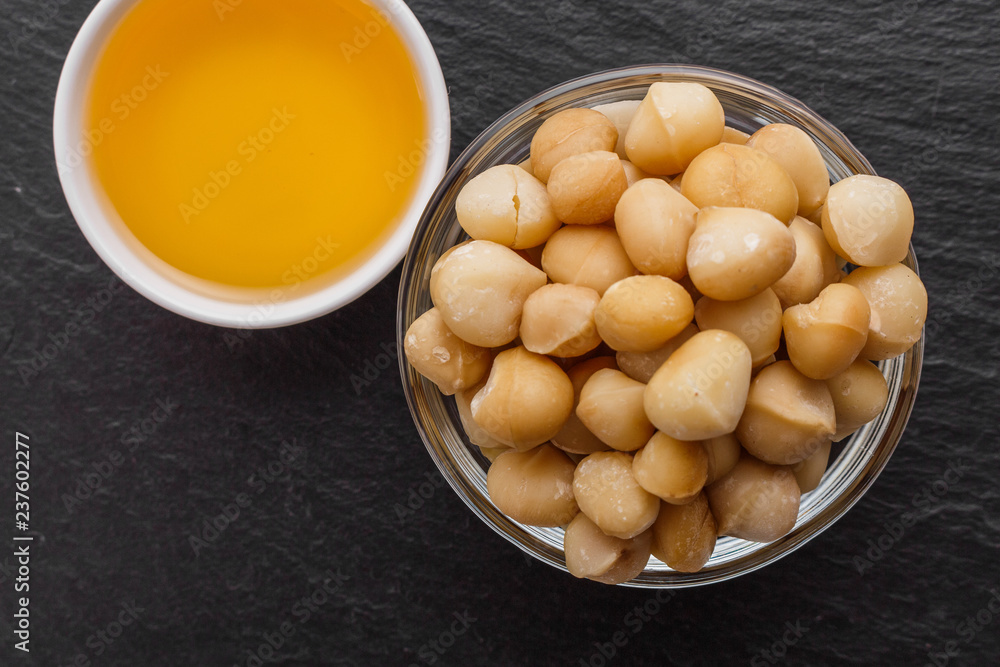 delicious macadamia nuts on a dark stone background delicious macadamia nuts on a dark stone background