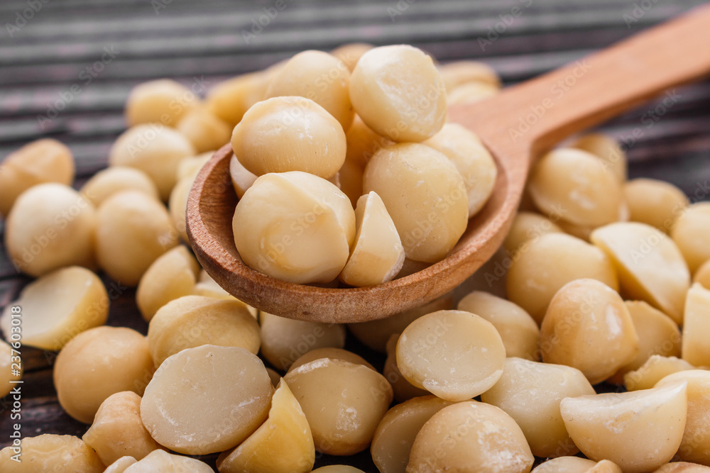 delicious macadamia nuts on a wooden rustic background delicious macadamia nuts on a wooden rustic background