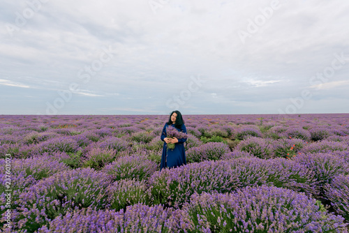 Young girl in blue dress, posing in a lavender field.