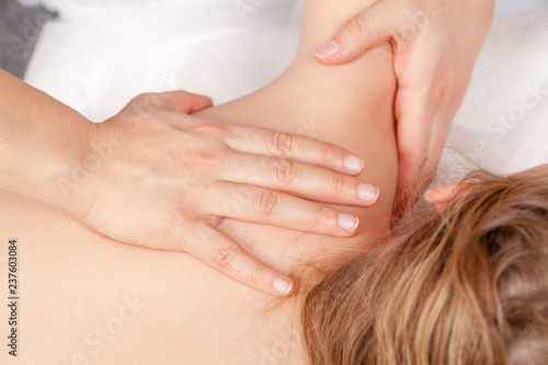 Tween girl receiving osteopathic treatment or medical massage of her shoulder