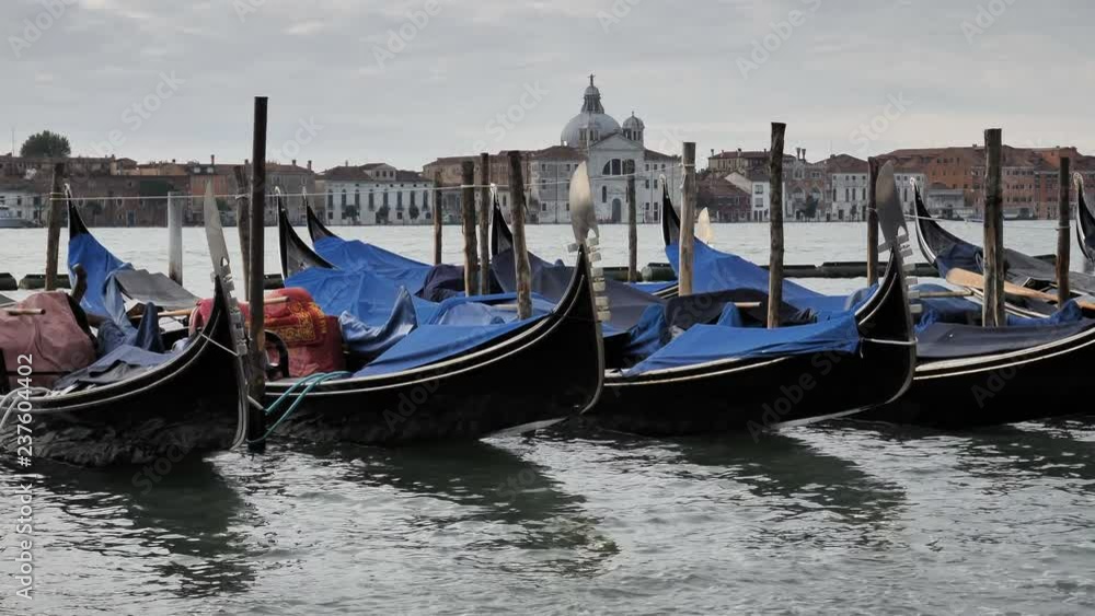 VENICE, ITALY, NOV 1st 2018: Gondolas parked near Grand Canal shore. Venezia, Italy. Classic venetian colorful cityscape with beautiful architecture on horizon. Scenic view from seacoast VENICE, ITALY, NOV 1st 2018: Gondolas parked near Grand Canal shore. Venezia, Italy. Classic venetian colorful cityscape with beautiful architecture on horizon. Scenic view from seacoast