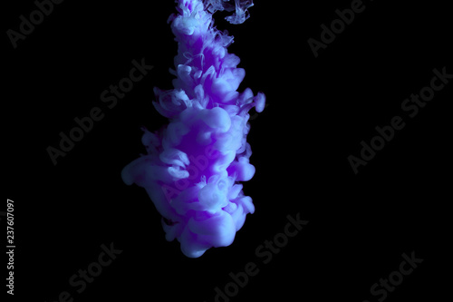 paint stream in water, colored ink cloud, abstract background, process of liquefaction blue dye on a black background