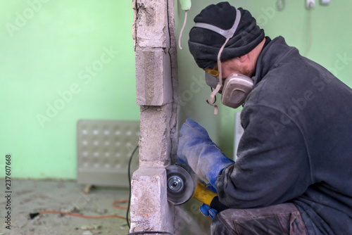 Construction worker cutting concrete wall by using electric cutter.