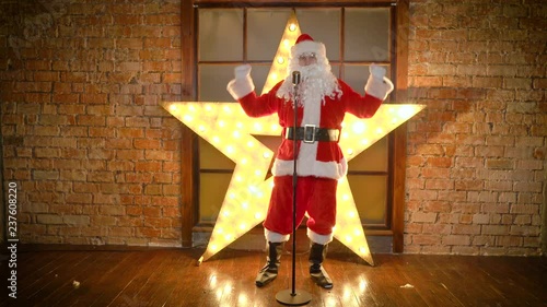 Santa Claus rock star, dances, sings funny christmas songs in retro microphone