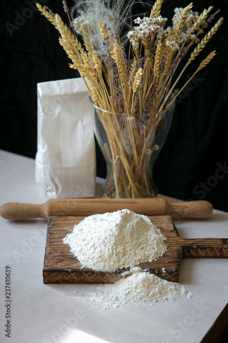 White flour for baking. Fine grinding, kitchen table, rolling pin, package. Recipe for traditional bread.