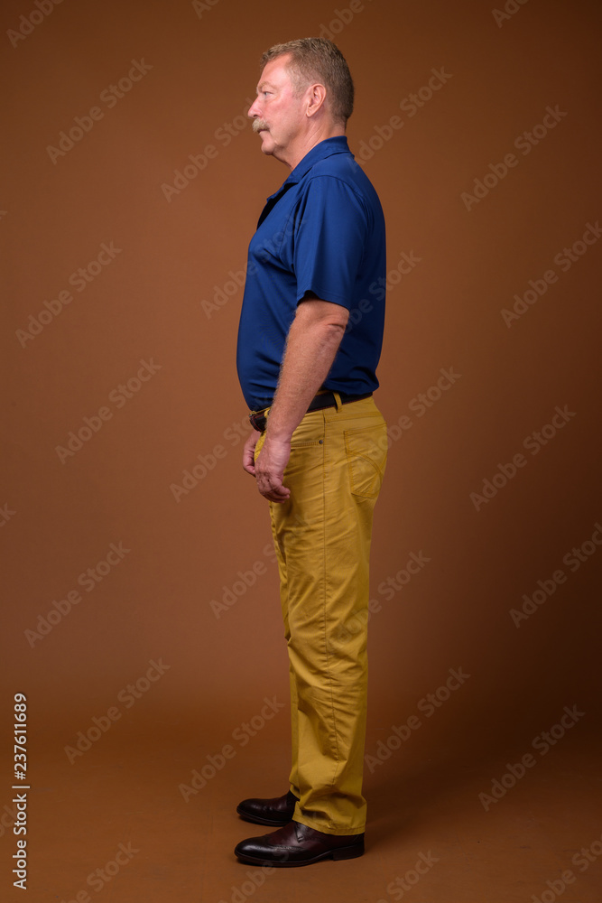 Fototapeta premium Full length profile view portrait of senior man standing