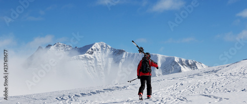 Skier with skis go up to top of mountain © BSANI