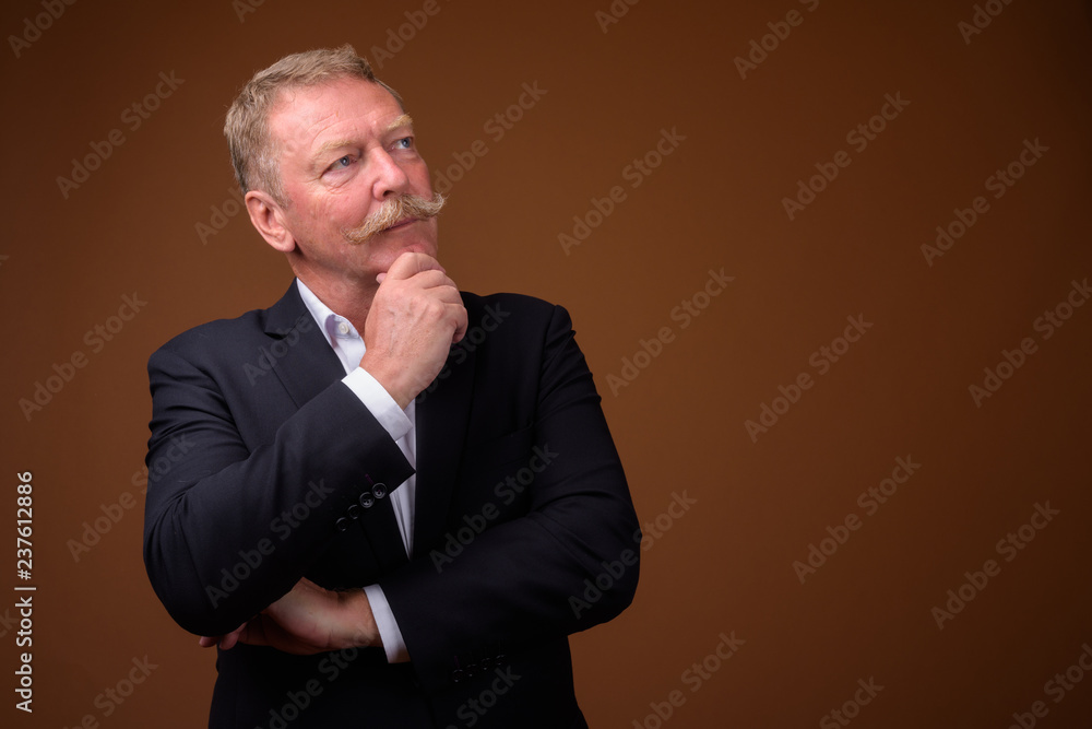 Handsome senior businessman with mustache thinking and looking up Handsome senior businessman with mustache thinking and looking up