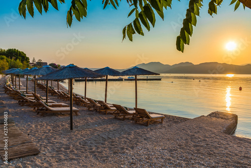 Fototapeta Naklejka Na Ścianę i Meble -  Nikiana beach with chairs and umbrellas at sunset time, Lefkada island, Greece