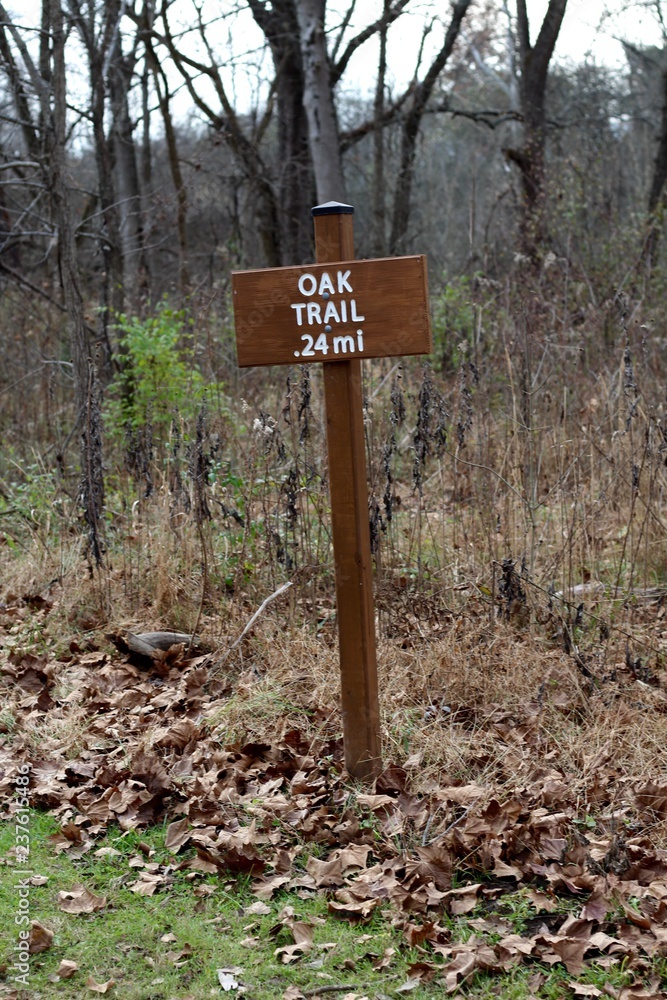 A brown wooden trail sign on the trail and a close up view. A brown wooden trail sign on the trail and a close up view.
