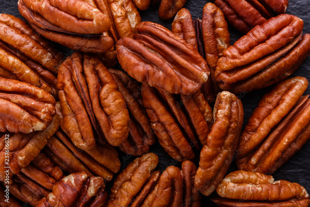 delicious pecan nuts on a dark stone background delicious pecan nuts on a dark stone background