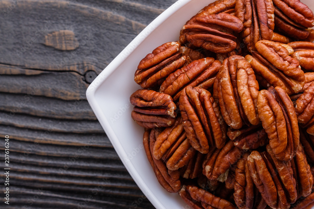 delicious pecan nuts on a rustic wooden background delicious pecan nuts on a rustic wooden background