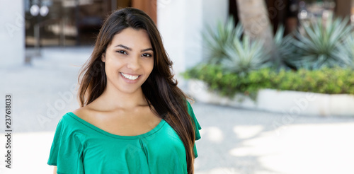 Free Download Laughing latin american woman in green shirt - GFXLoad