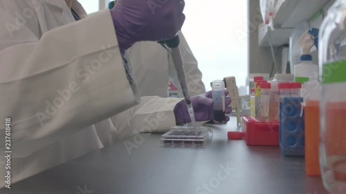 A Scientist Using a Syringe to Transfer Liquid
