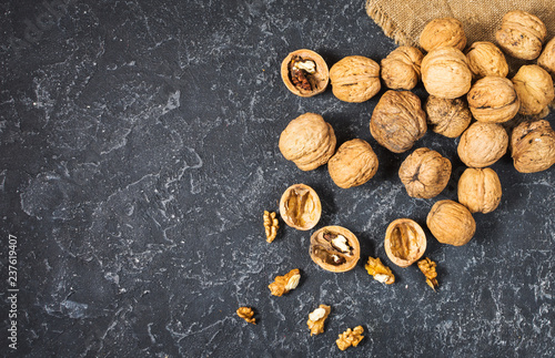 Walnut kernels on a dark stone background.