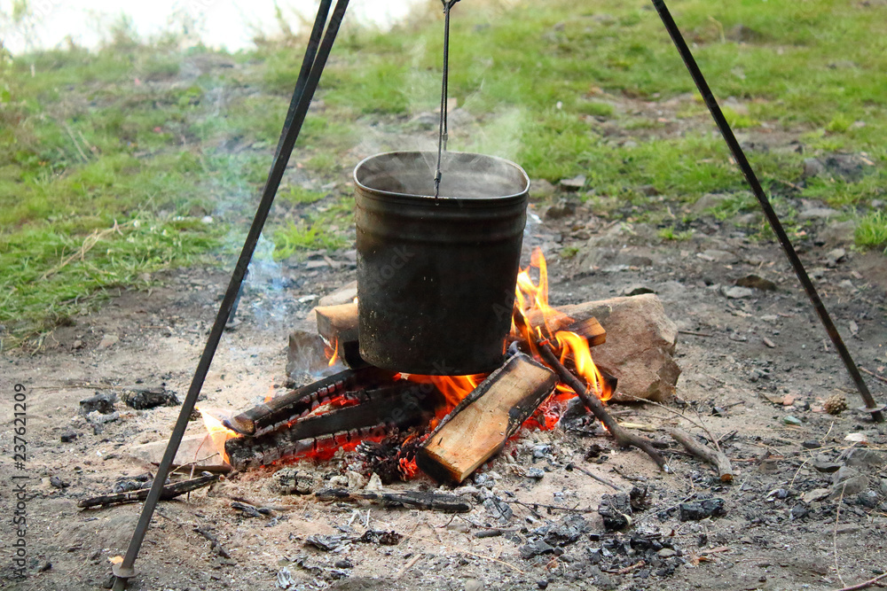 The water in the pot is heated on the fire. Close-up. Background. The water in the pot is heated on the fire. Close-up. Background.