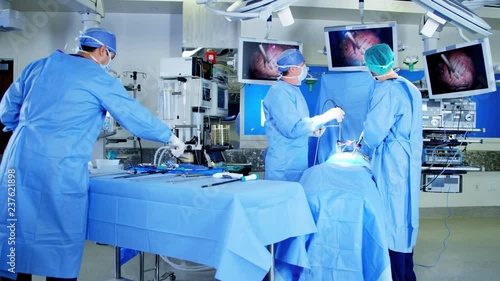 Caucasian European male team in scrubs in the operating theater of European origin using an Endoscopy to specialise in Laparoscopy surgery via camera technology 