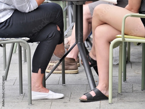 Many kinds of legs, people legs, women legs, table legs, chair legs, tables and chairs in an restaurant