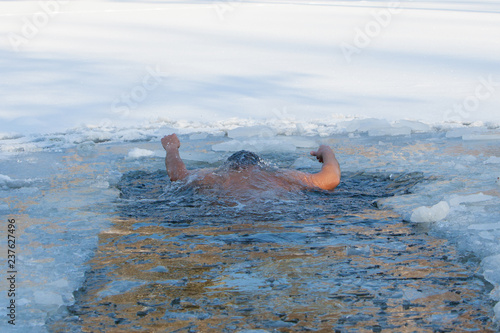 Men swims invisible under water hands are up in ice hole, Drown 