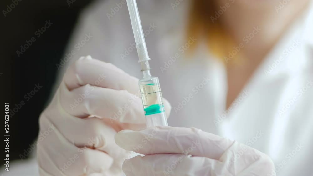 Hands of a doctor in medical gloves before making an injection remove air bubbles from a syringe Hands of a doctor in medical gloves before making an injection remove air bubbles from a syringe