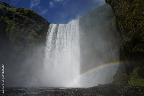 Skógafoss on Iceland in summer wih rainbow and blue sky