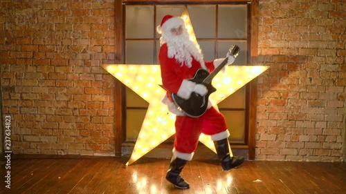 Santa Claus rock star, plays christmas songs by guitar, have fun, celebrate holidays
