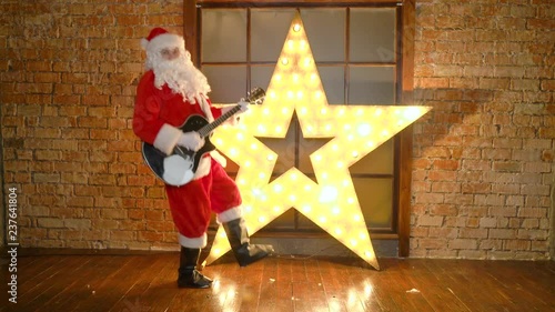 Santa Claus rock star, plays christmas songs by guitar, have fun, celebrate holidays