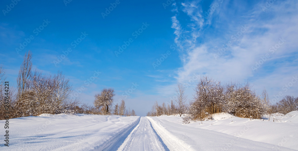 Countryside road through winter field with forest on a horizon. Artistic picture. Beauty world. Countryside road through winter field with forest on a horizon. Artistic picture. Beauty world.