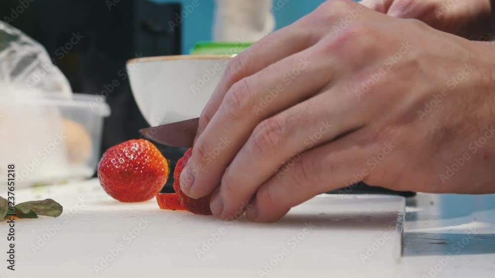 A person cutting strawberries on the kitchen A person cutting strawberries on the kitchen