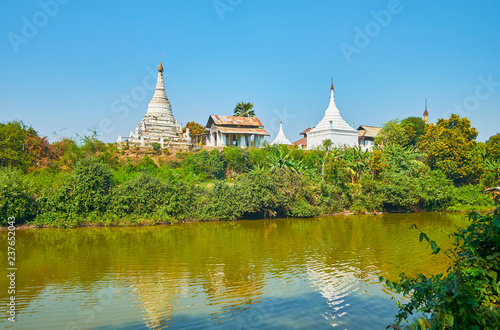 The ancient stupas of the Buddhist Monastery are reflected in waters of the narrow canal of Ava (Inwa), Myanmar. photo