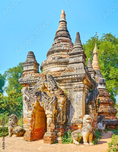 The ornate shrine of Daw Gyan Pagoda complex with guardian statues of Chinthe (leogryphs) and carved patterns on the gate and cone of the building, Ava (Inwa), Myanmar. photo