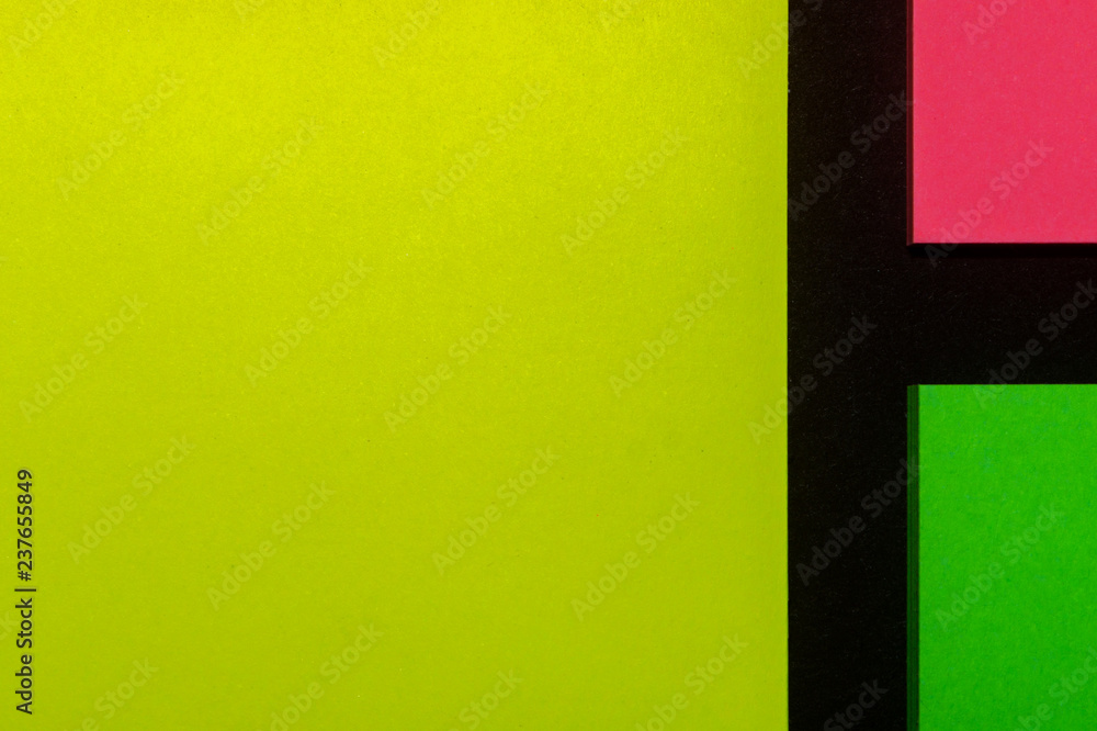 Fototapeta premium Green, yellow and pink hue colorful office stickers on black paper. Office noteparer as reminder. Isolated on black paper.