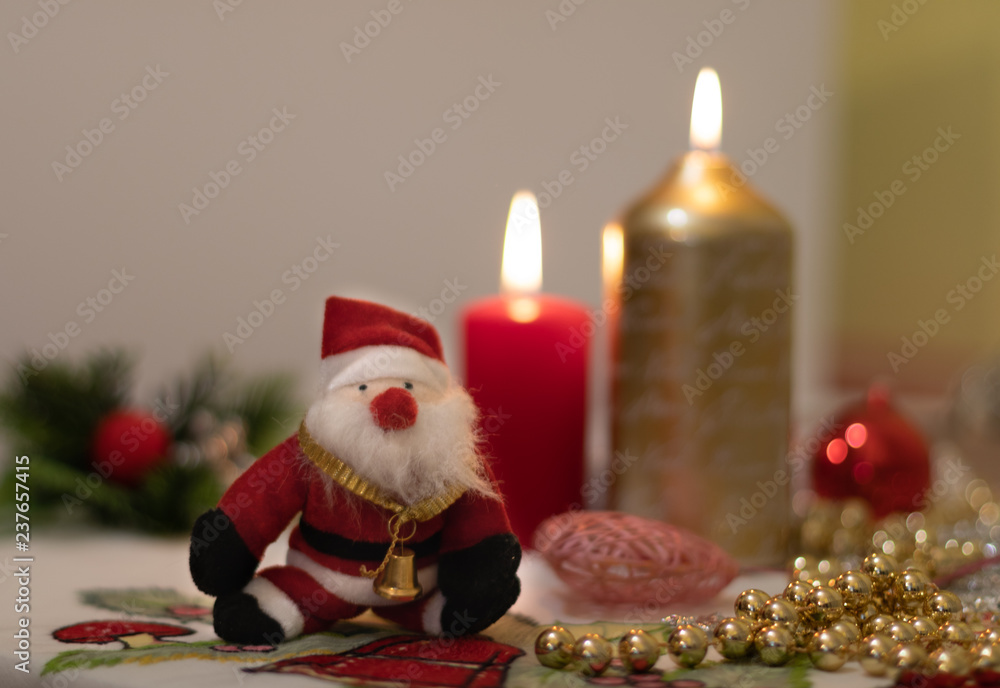 Santa Claus doll with candles on a Christmas tablecloth Santa Claus doll with candles on a Christmas tablecloth