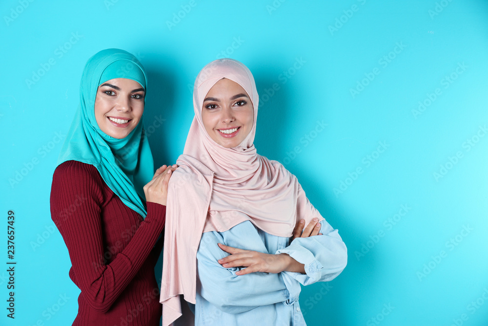 Portrait of young Muslim women in hijabs against color background Portrait of young Muslim women in hijabs against color background