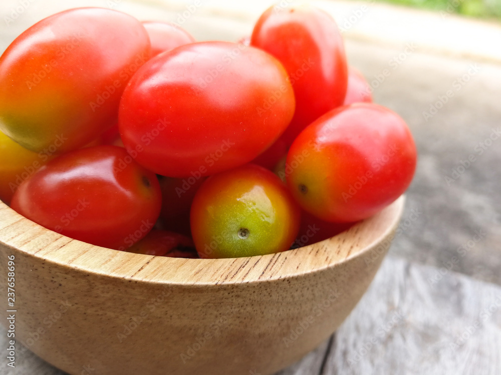 fresh tomato cherry / ripe red tomato in wooden bowl on wood backfground - red tomato vine fruit and vegetable fresh tomato cherry / ripe red tomato in wooden bowl on wood backfground - red tomato vine fruit and vegetable