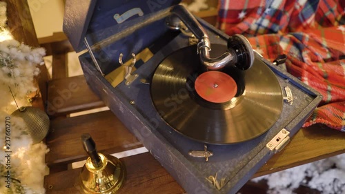 Gramophone plays christmas songs on vinyl record. Phonograph plays old music song on vinyl plate