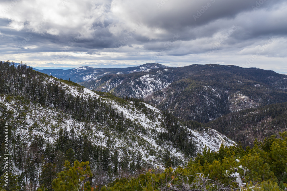 Dramatic landscape. Mountains covered with first snow with a cloudy sky from above.