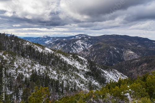 Dramatic landscape. Mountains covered with first snow with a cloudy sky from above.