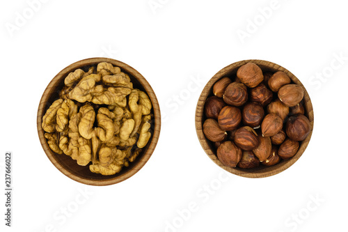 Wooden bowl with hazelnuts and wallnuts isolated on white background. The view from the top.