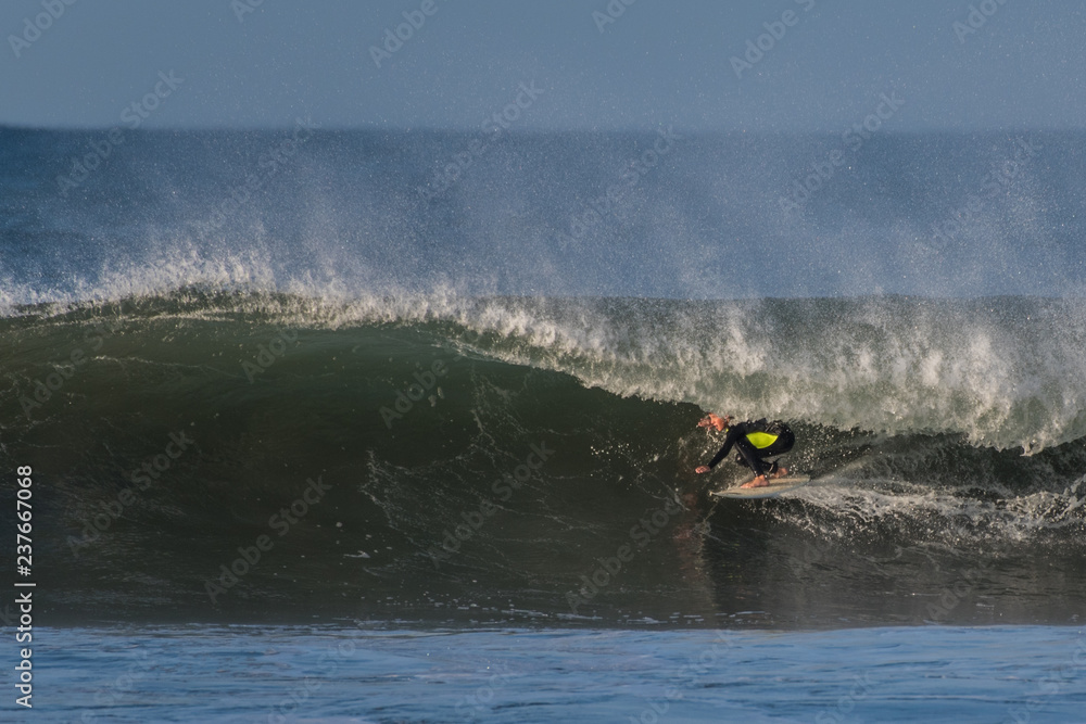 Surfer in low crouch as he shoots through a hollow section of a fun wave in Ventura during a late Autumn swell. Surfer in low crouch as he shoots through a hollow section of a fun wave in Ventura during a late Autumn swell.