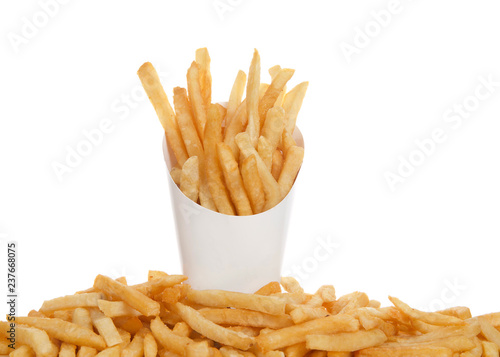 White cup full of french fries with french fries below on table isolated on white background. French fries have been popularized worldwide in large part by the large American fast food chains. photo