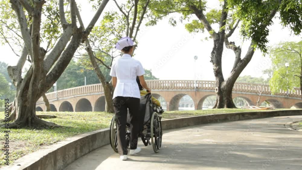 Young nurse take caring old woman on wheelchair in the park Young nurse take caring old woman on wheelchair in the park