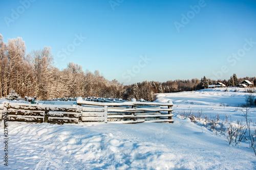winter rural landscape with frozen trees and fence