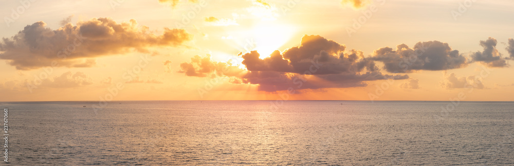 Fototapeta premium Panoramiczny piękny widok na zachód słońca nad oceanem. Сolorful zachmurzone niebo i zachodzące słońce