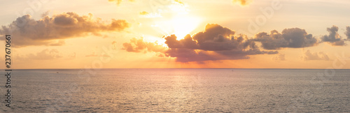 Panoramic beautiful view on sunset over the ocean. Сolorful cloudy sky and setting sun photo