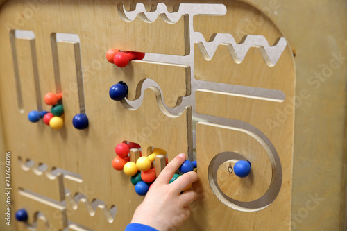 Child's hand plays with wooden puzzle photo